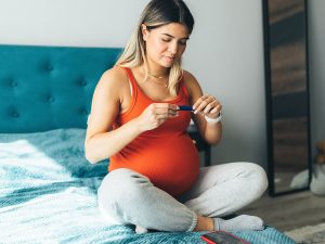 Pregnant woman checking blood glucose
