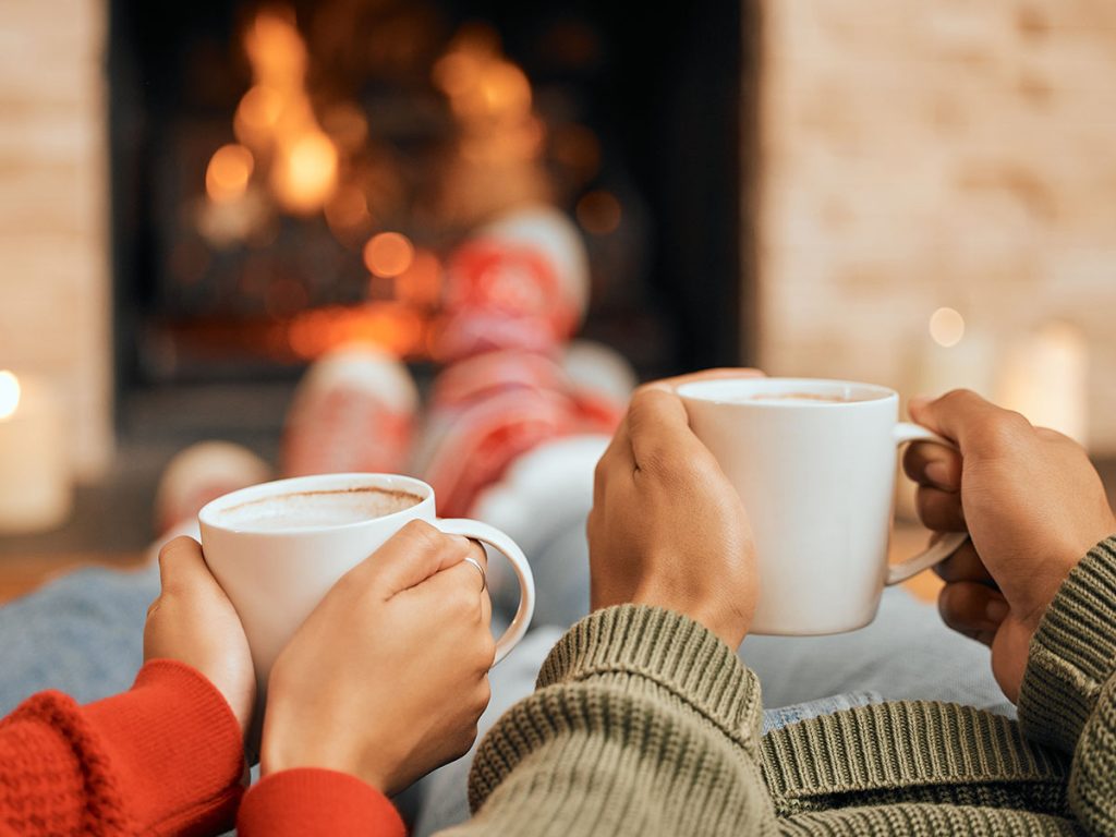 Couple enjoying winter drinks in front of fire
